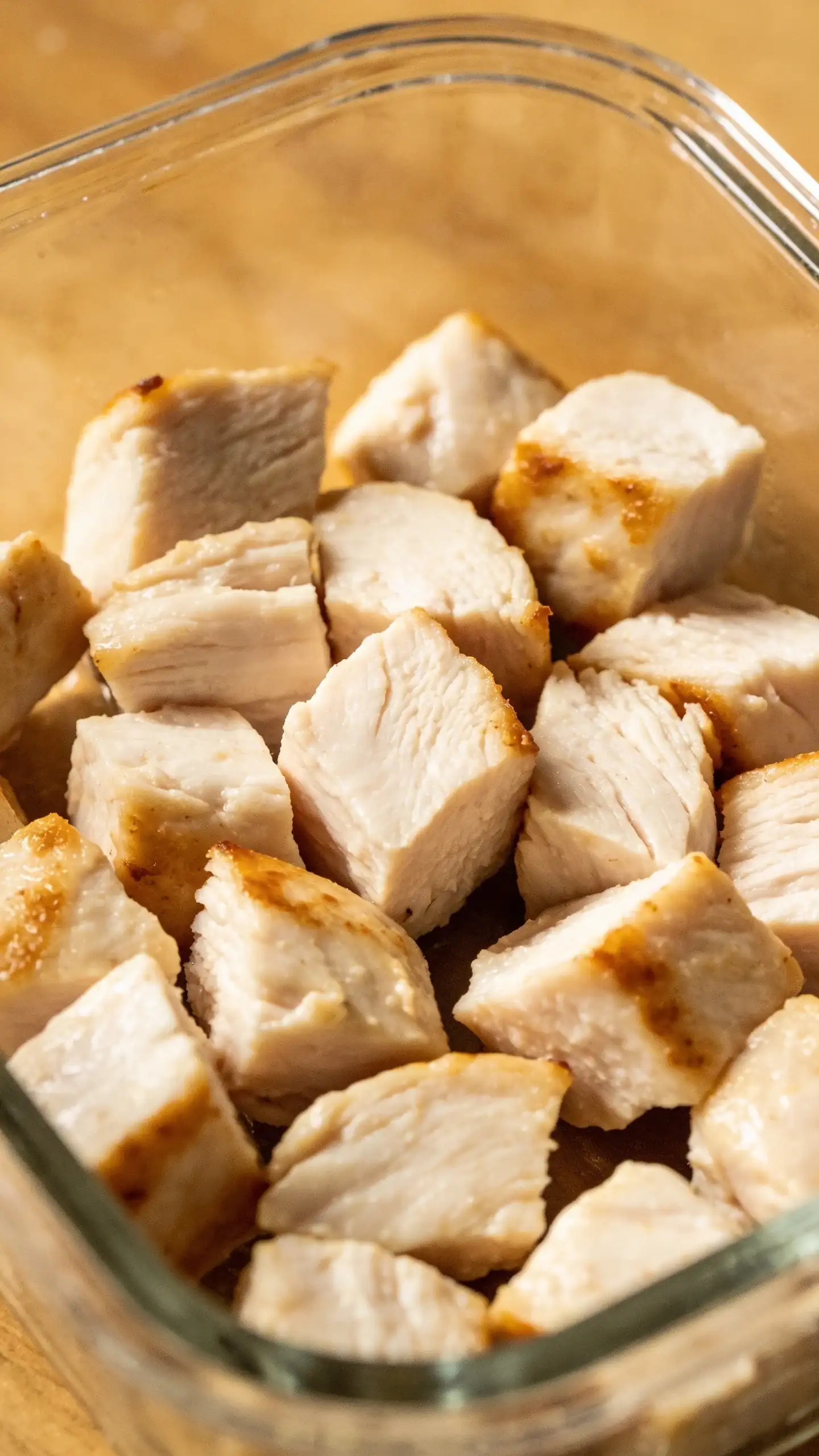 cooked chicken breast cubes in glass meal-prep container